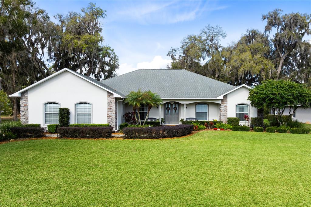 4846 Calasans Avenue St. Cloud, FL 34771 - Photo 48 of 61 a front view of a house with a yard and trees