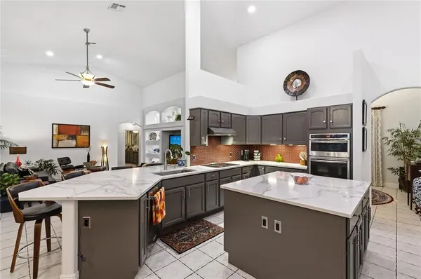 a kitchen with a sink a stove and chairs