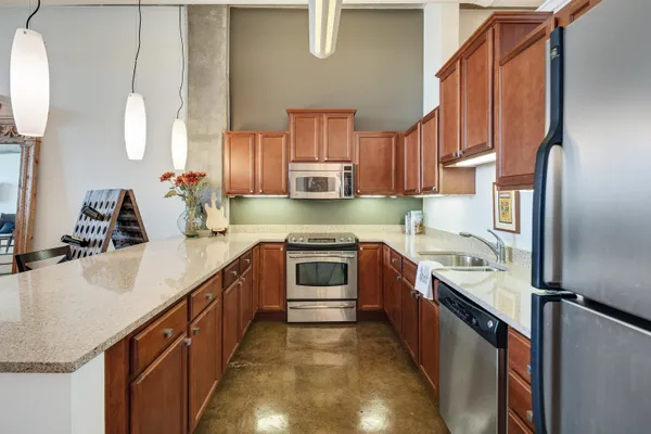 a kitchen with stainless steel appliances granite countertop a sink a stove and a refrigerator