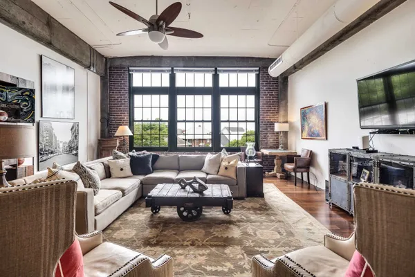 a living room with furniture ceiling fan and a flat screen tv