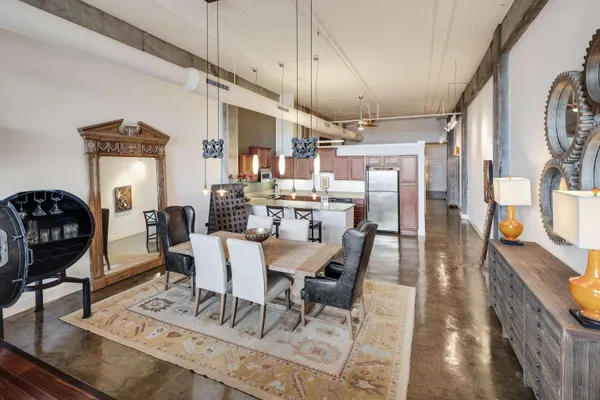 a view of a dining room with furniture a rug and wooden floor