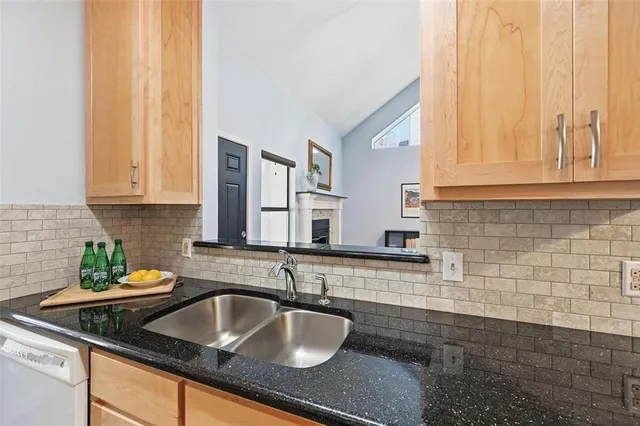 a kitchen with granite countertop a sink and a white cabinets