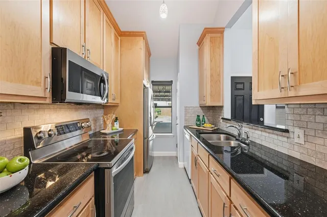 a kitchen with stainless steel appliances granite countertop a stove a sink and a microwave