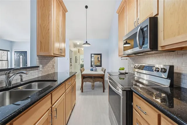 a kitchen with stainless steel appliances granite countertop a sink and stove top oven