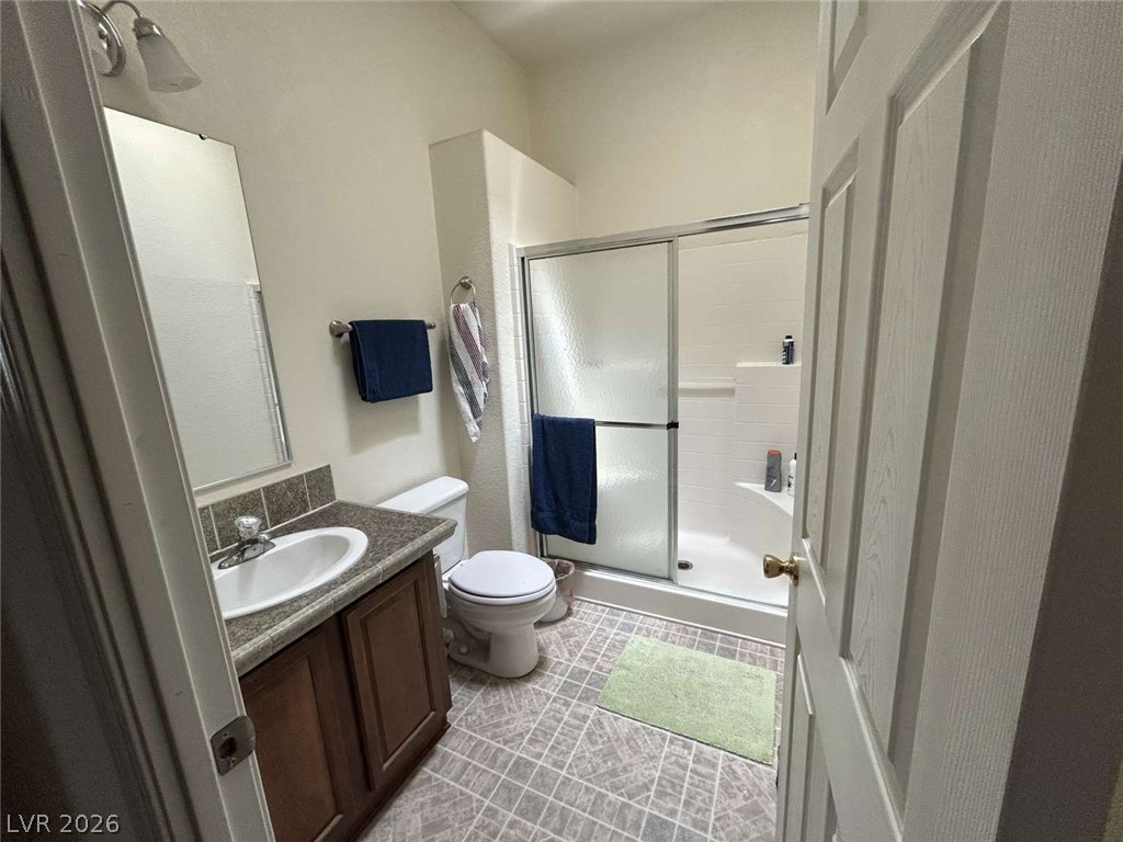 4980 Retread Road Pahrump, NV 89048 - Photo 19 of 20 This bright bathroom features a vanity with a sleek countertop and a convenient shower.