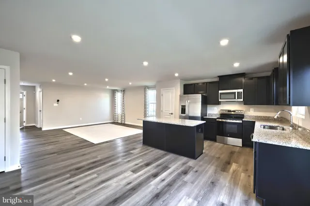 an open space with kitchen view and wooden floor