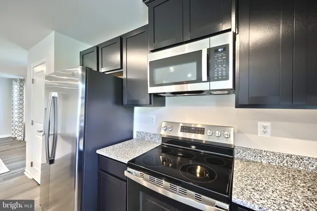 a large kitchen with granite countertop lots of counter space and sink