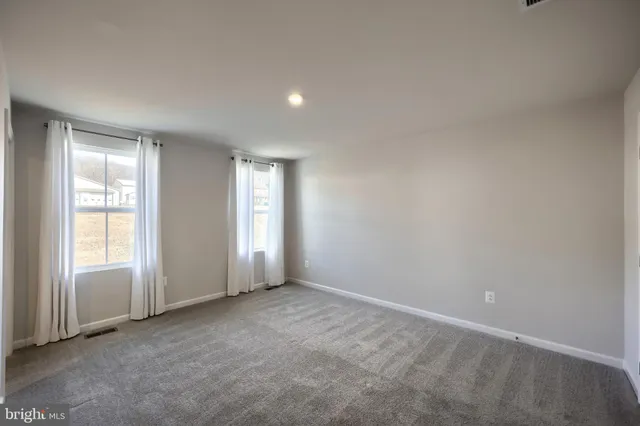 an empty room with wooden floor and a fireplace