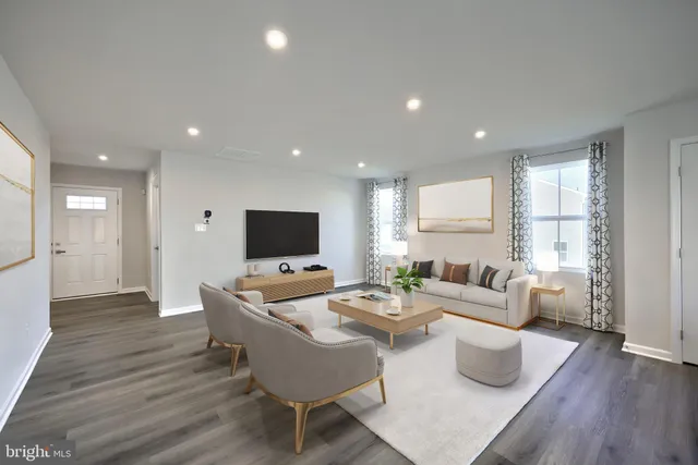 a living room with furniture a wooden floor and a flat screen tv