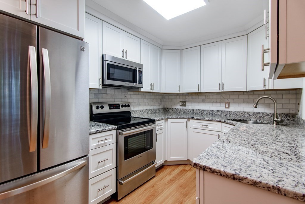 64 Jacqueline Road, Unit 3 Waltham, MA 02452 - Photo 4 of 27 a kitchen with granite countertop a sink stove and refrigerator