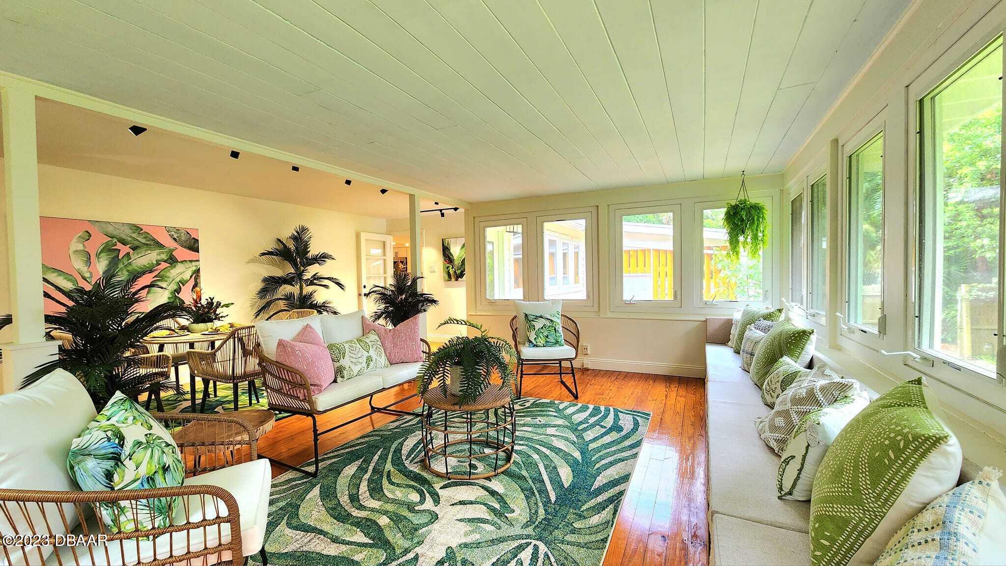 912 North Halifax Drive Ormond Beach, FL 32176 - Photo 19 of 65 a living room with furniture dining table and a large window