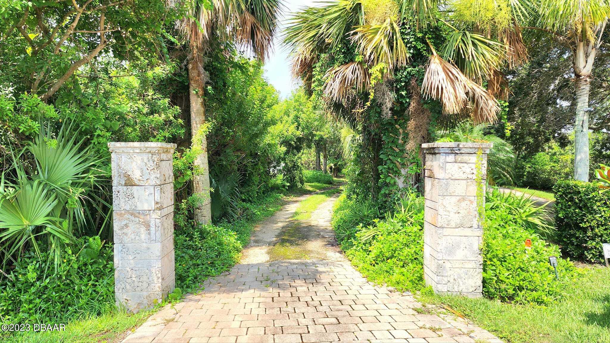 912 North Halifax Drive Ormond Beach, FL 32176 - Photo 2 of 65 a pathway of a house with a yard and sitting area