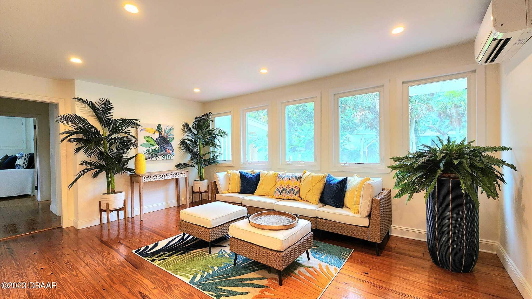 912 North Halifax Drive Ormond Beach, FL 32176 - Photo 30 of 65 a living room with furniture and a large window with wooden floor