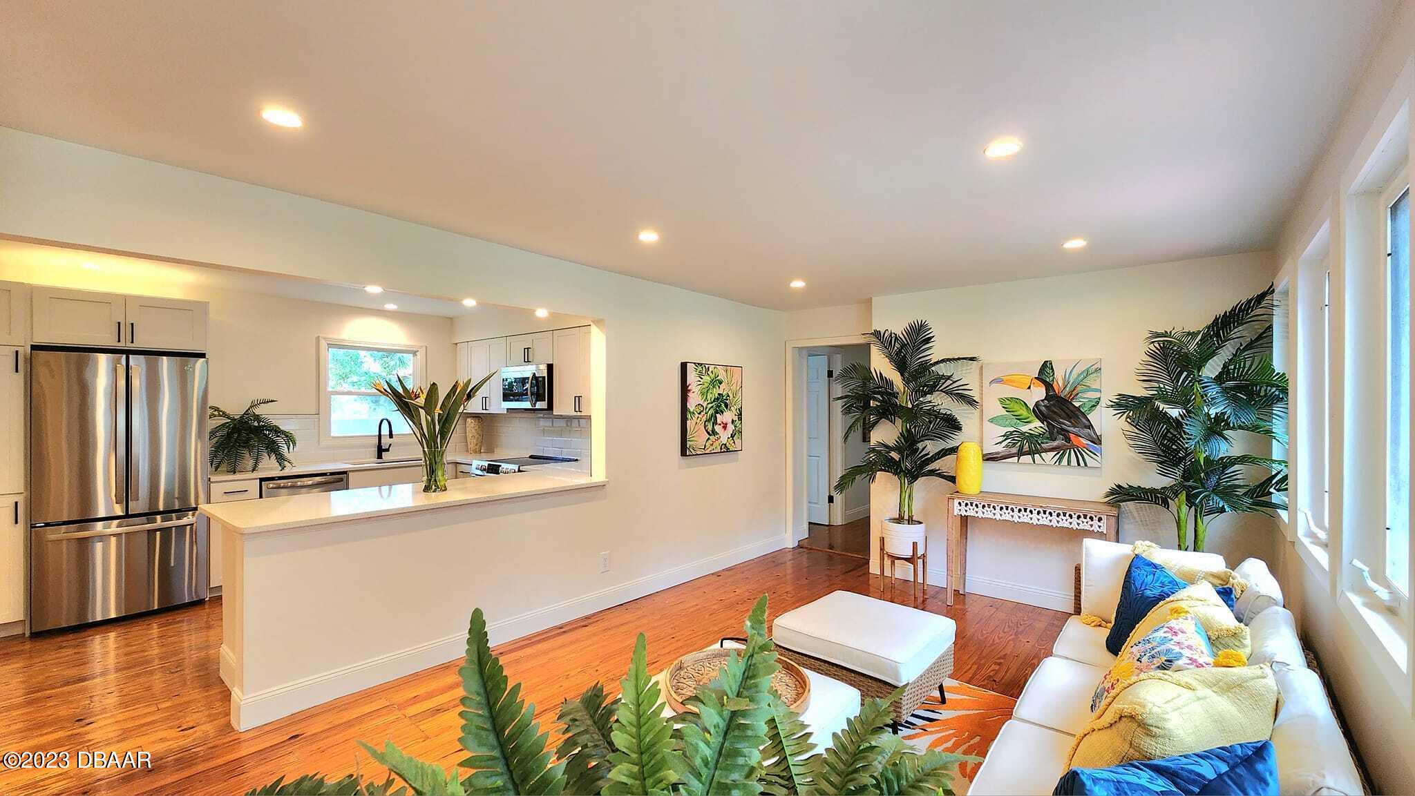 912 North Halifax Drive Ormond Beach, FL 32176 - Photo 32 of 65 a living room with stainless steel appliances furniture a rug and a kitchen view