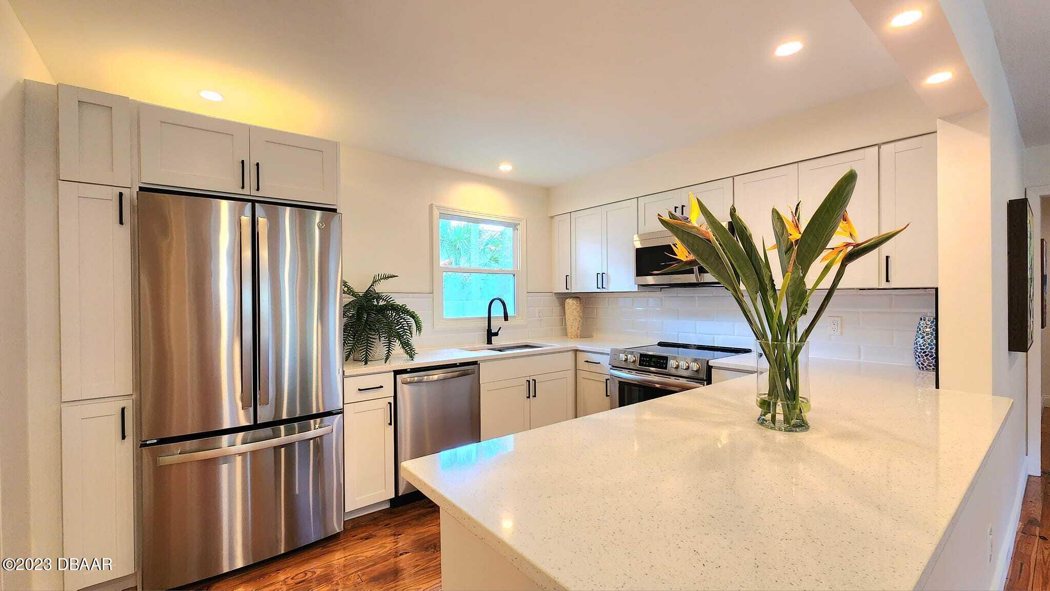 912 North Halifax Drive Ormond Beach, FL 32176 - Photo 34 of 65 a kitchen with stainless steel appliances a refrigerator sink and cabinets