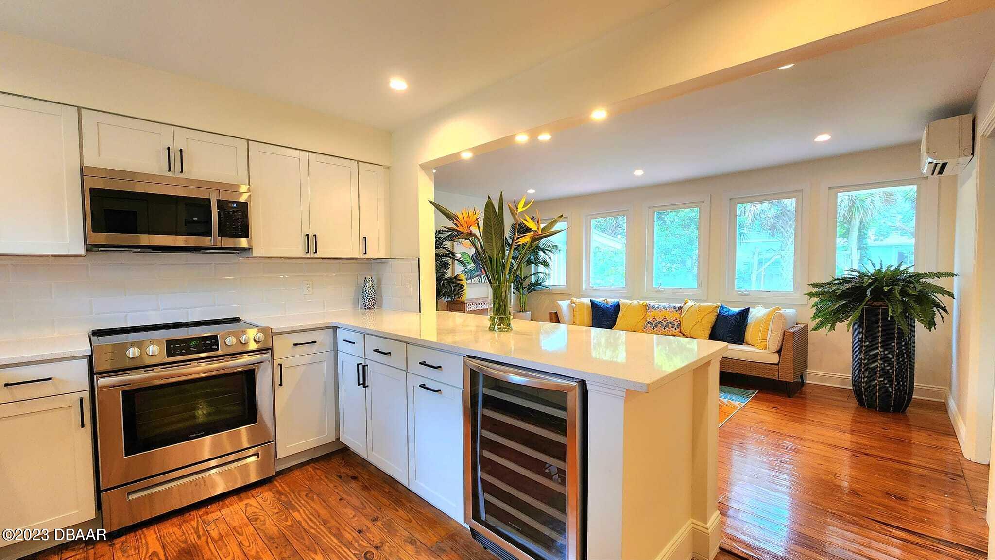 912 North Halifax Drive Ormond Beach, FL 32176 - Photo 35 of 65 a kitchen with stainless steel appliances a stove a sink and a microwave