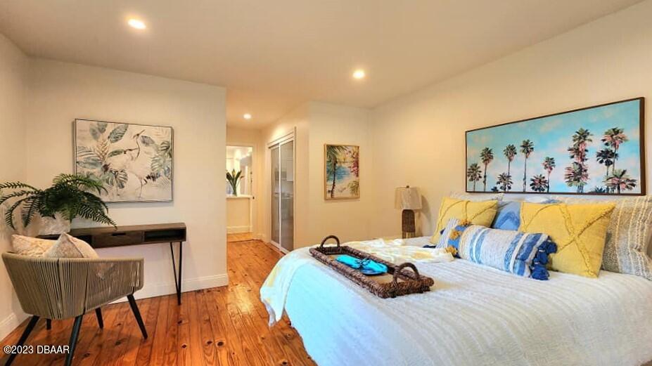 912 North Halifax Drive Ormond Beach, FL 32176 - Photo 43 of 65 a bedroom with a bed and wooden floor