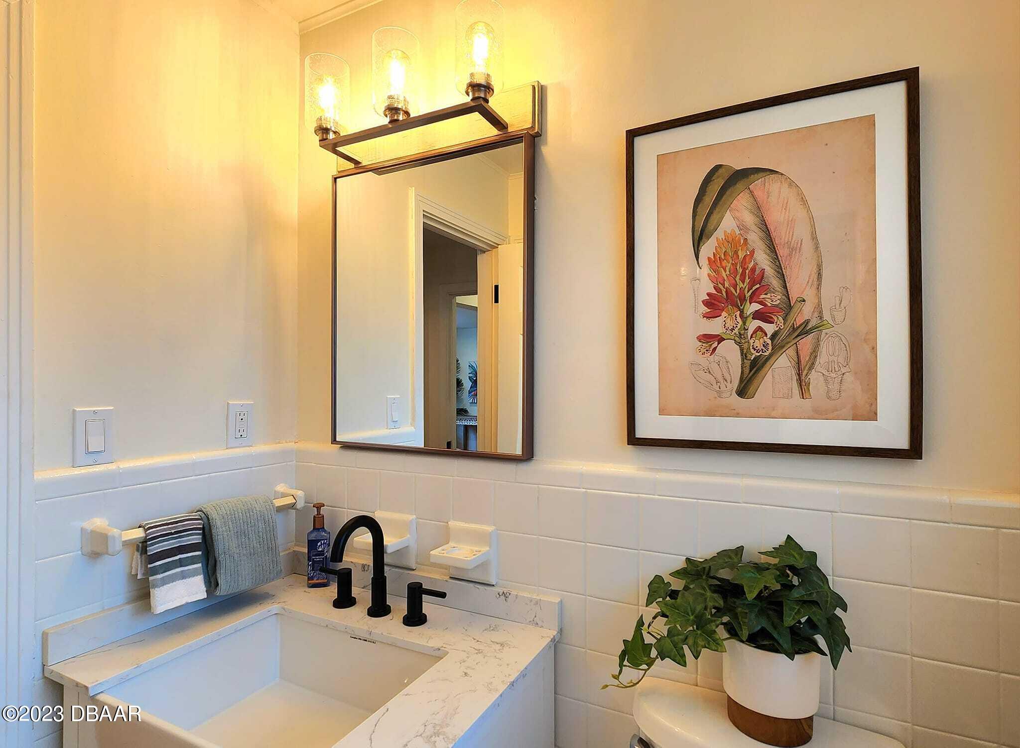 912 North Halifax Drive Ormond Beach, FL 32176 - Photo 46 of 65 a bathroom with a sink and a mirror