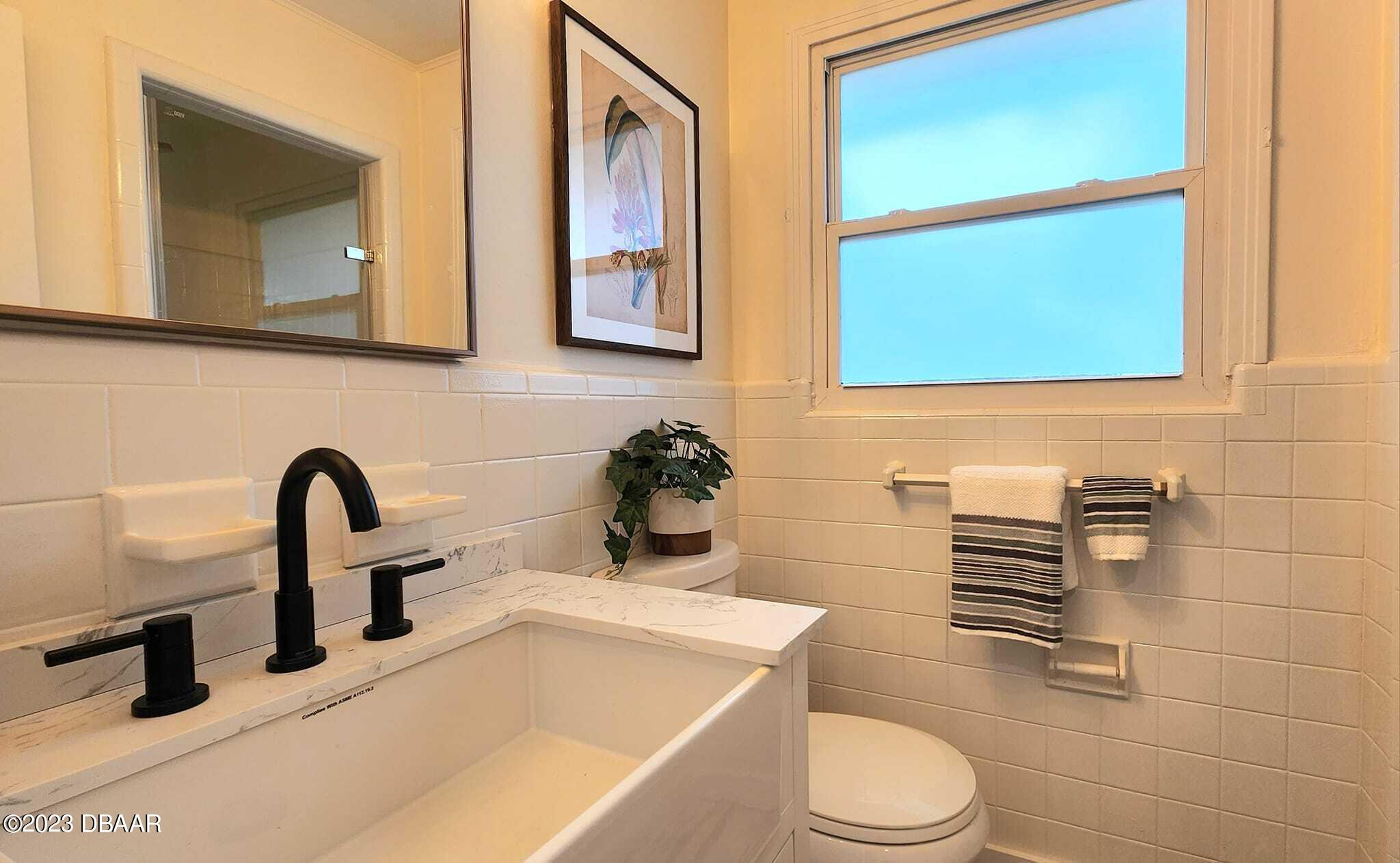 912 North Halifax Drive Ormond Beach, FL 32176 - Photo 48 of 65 a bathroom with a toilet sink and mirror