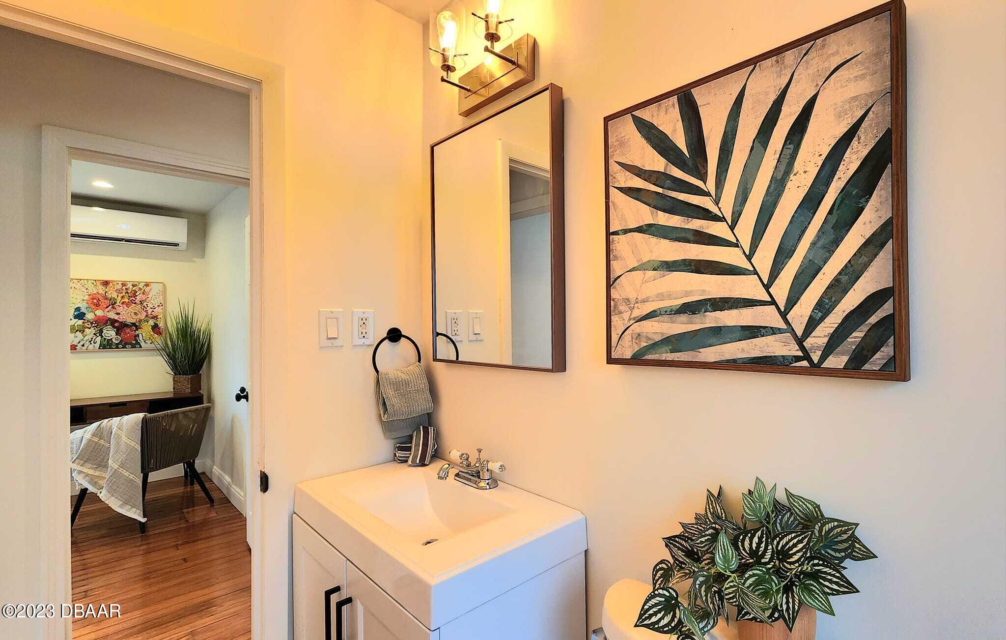 912 North Halifax Drive Ormond Beach, FL 32176 - Photo 56 of 65 a bathroom with a sink a mirror and a painting on the wall