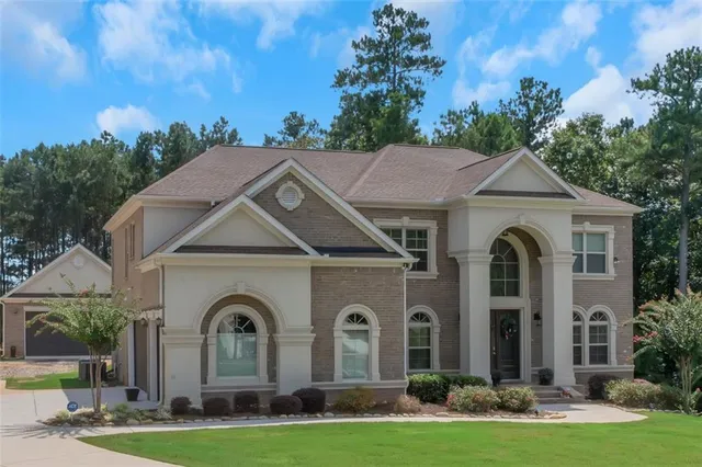 an aerial view of a house with outdoor space and trees all around
