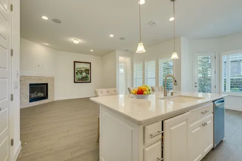 a kitchen with a sink a stove and chairs