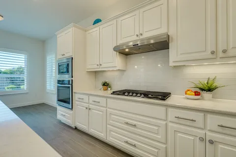 a kitchen with stainless steel appliances white cabinets and a stove