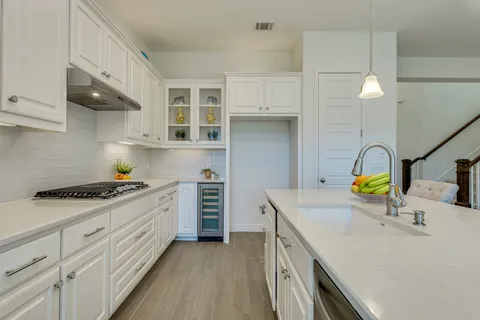 a kitchen with stainless steel appliances granite countertop a sink stove and cabinets