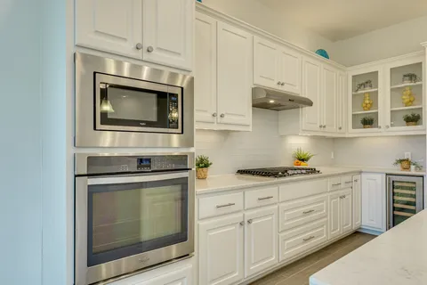 a kitchen with stainless steel appliances granite countertop white cabinets a sink and dishwasher