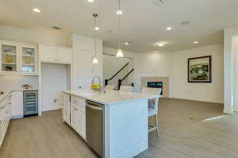a kitchen with a sink a stove and chairs