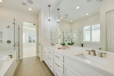 a bathroom with double vanity sinks and a bathtub