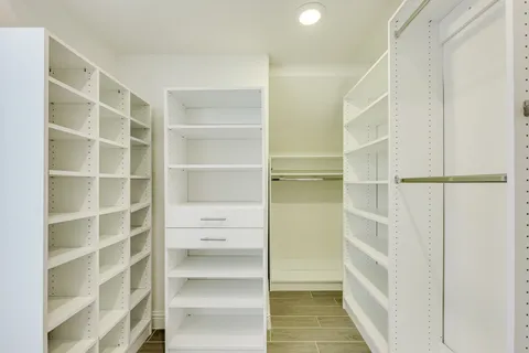 a view of walk in closet with empty racks