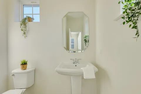 a bathroom with a sink mirror and toilet