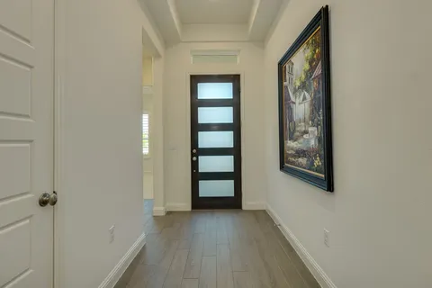 a view of a hallway with wooden floor and closet