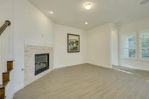 an empty room with windows and fireplace