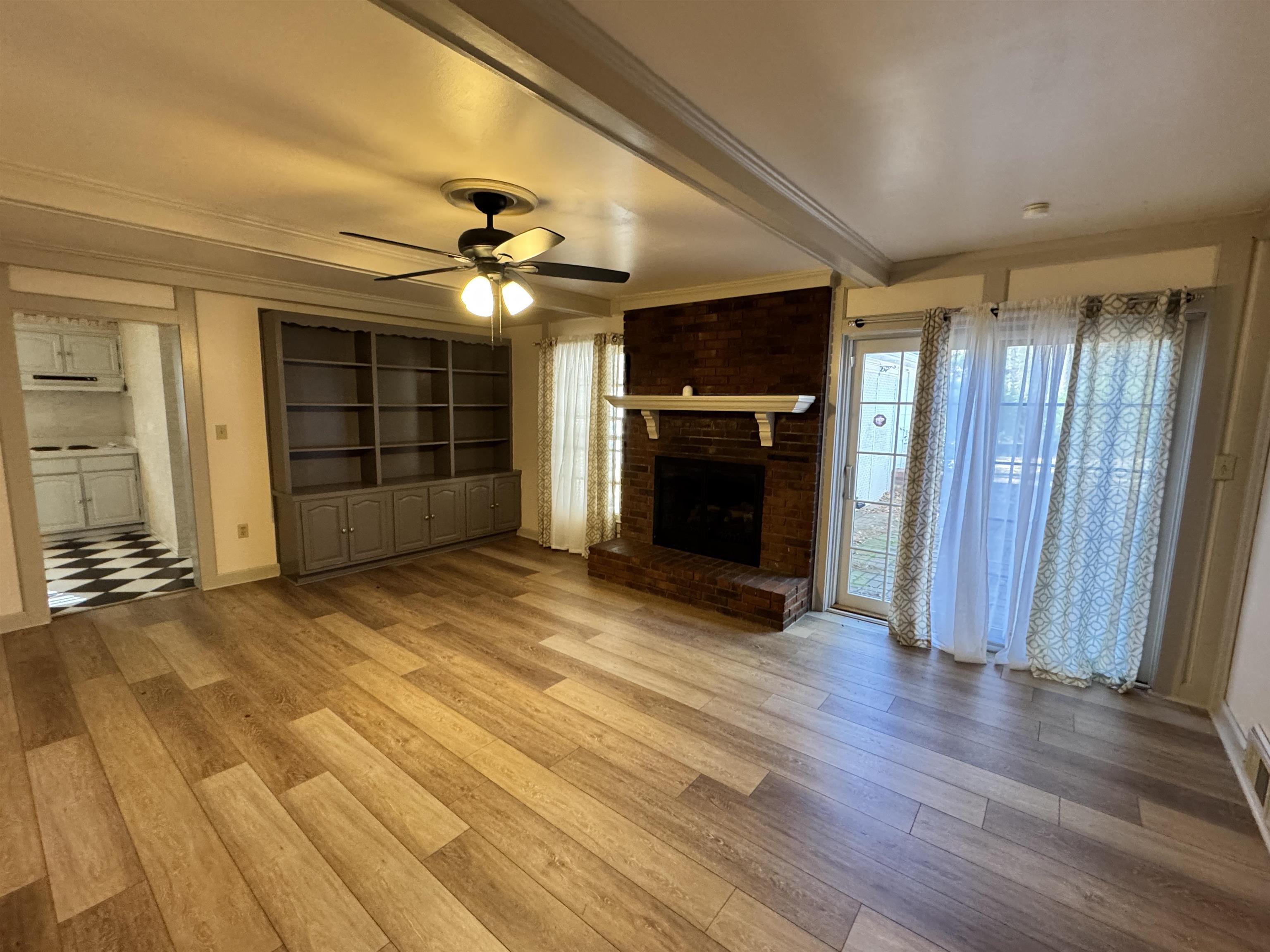 1979 Kirby Parkway Memphis, TN 38119 - Photo 7 of 28 an empty room with wooden floor fireplace and windows