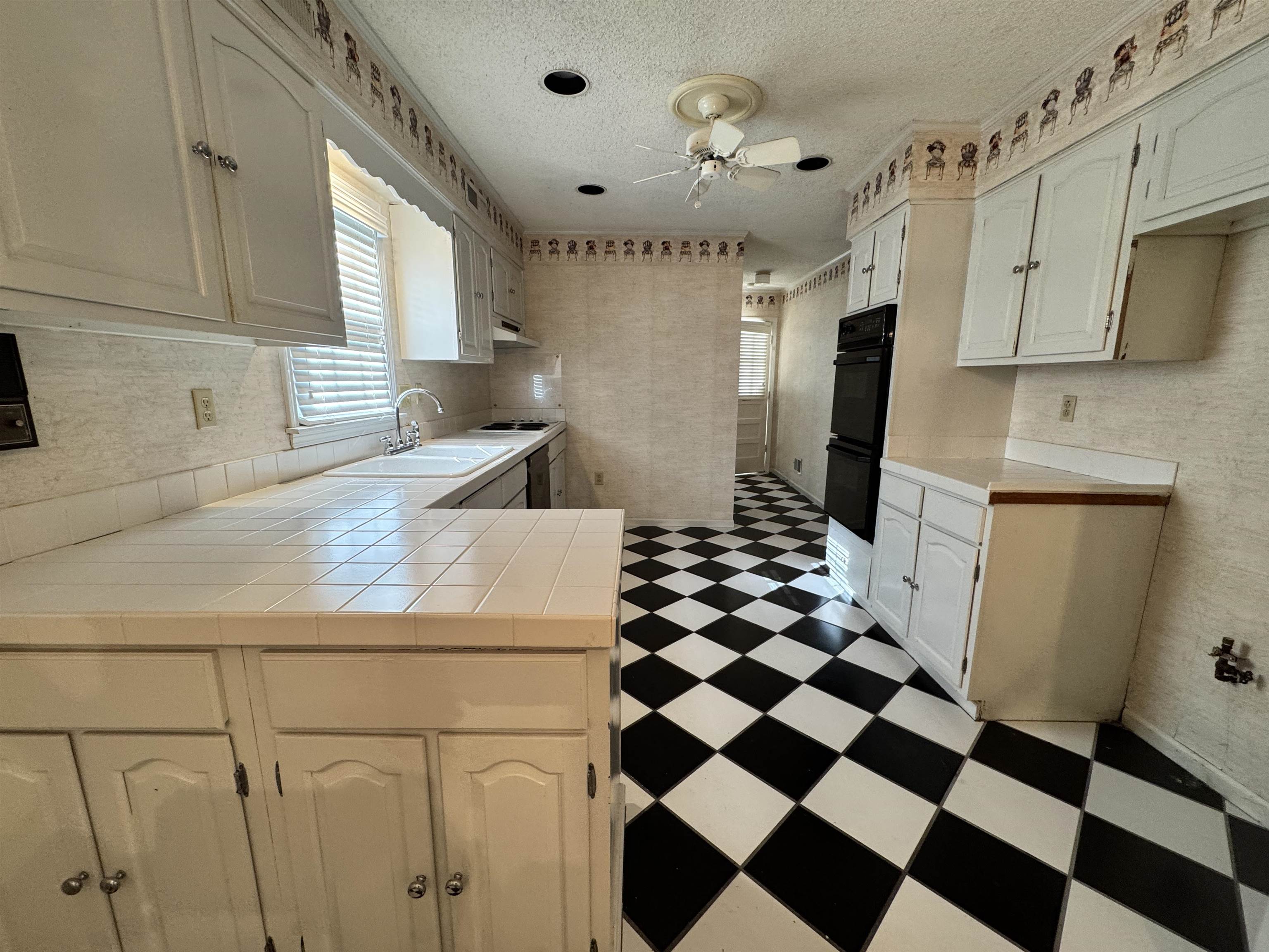 1979 Kirby Parkway Memphis, TN 38119 - Photo 9 of 28 a kitchen with a checkered floor and white cabinets