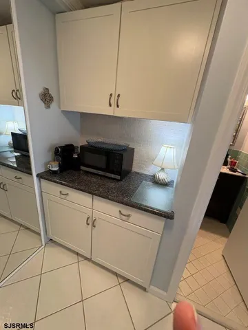 a kitchen with granite countertop a sink a stove and cabinets