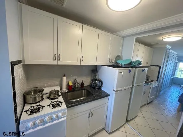 a kitchen with a sink a refrigerator and cabinets