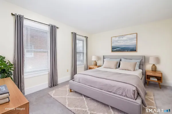 a bedroom with a bed and a painting on the wall