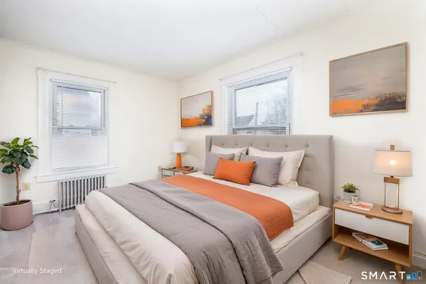a bedroom with bed and a potted plant