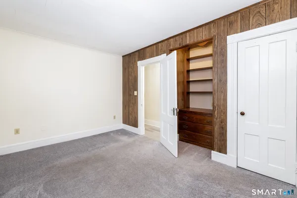 an empty room with closet and windows