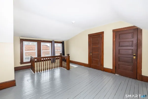an empty room with furniture and wooden floor