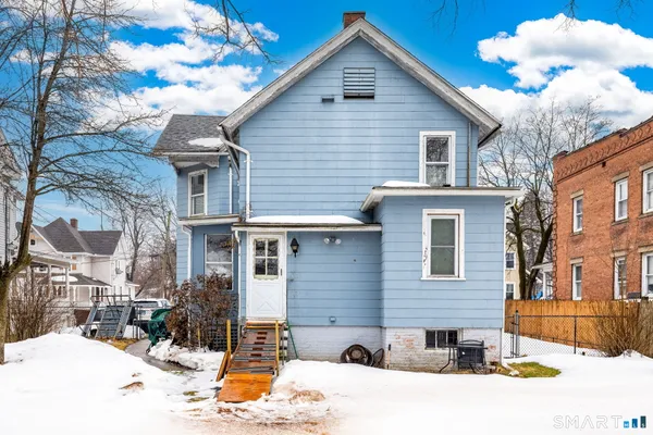 a view of a house with a yard covered in snow