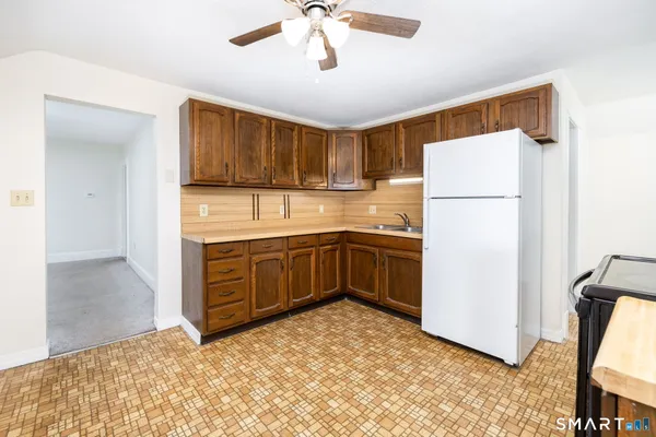 a kitchen with a refrigerator sink and cabinets
