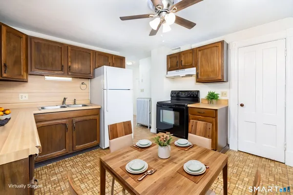 a kitchen with stainless steel appliances granite countertop a sink a stove a dining table and chairs