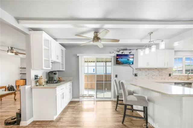 a kitchen with a dining table chairs cabinets and stainless steel appliances
