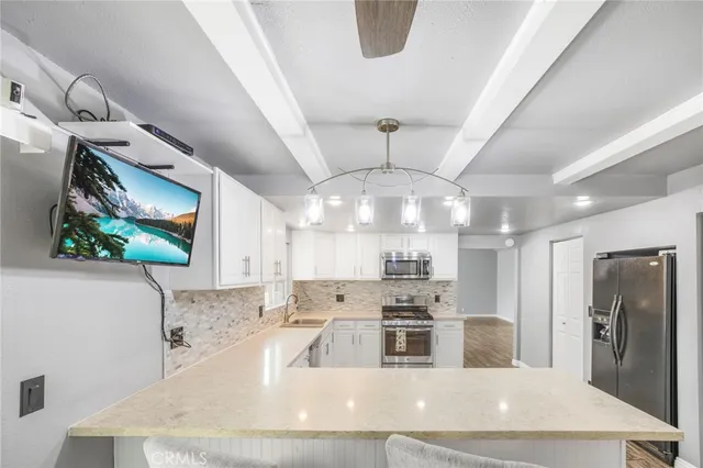 a large kitchen with stainless steel appliances a large counter top a stove a sink dishwasher and microwave