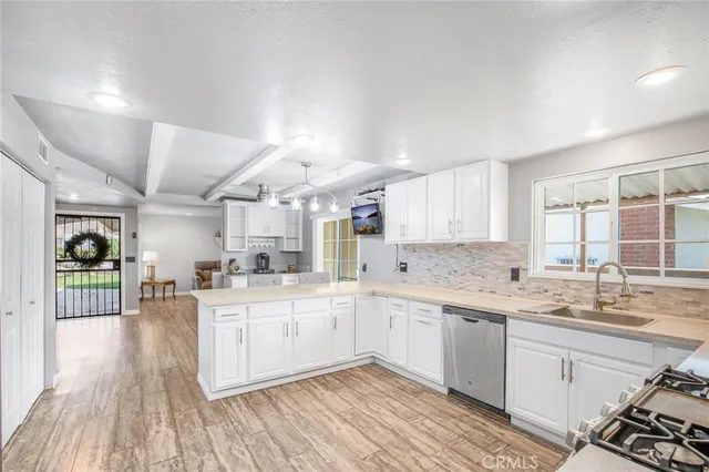 a kitchen with a sink stove cabinets and wooden floor