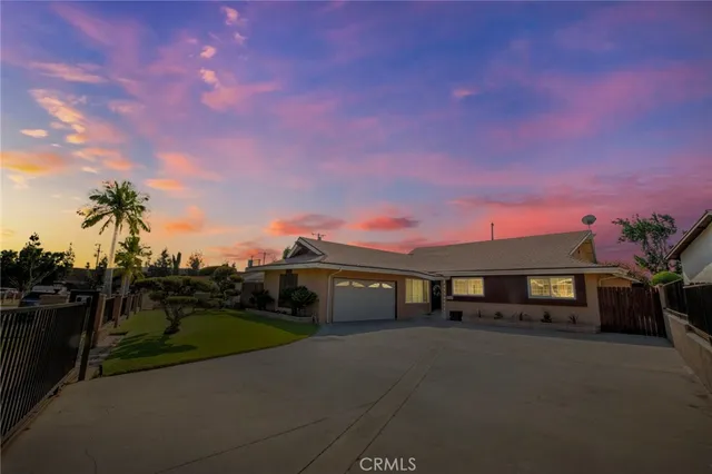 a front view of a house with a garden and a yard